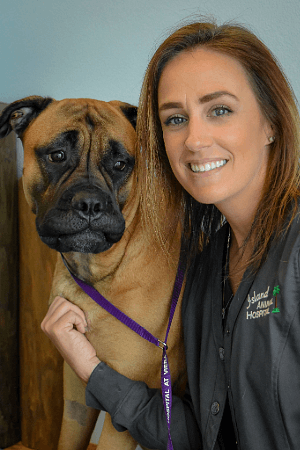 female with medium length auburn hair posing with a Bullmastiff