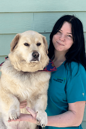 Female with long back hair posing with a large sandy brown dog